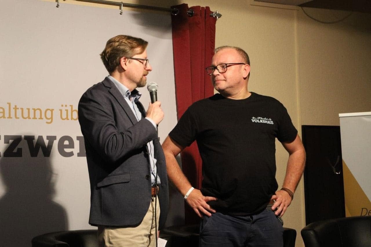 HEIMAT-Bundesvorsitzender Peter Schreiber und Patrick Wieschke auf der Bühne im Flieder Volkshaus Eisenach